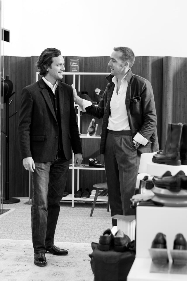 Two men in a shoe store examining shoes