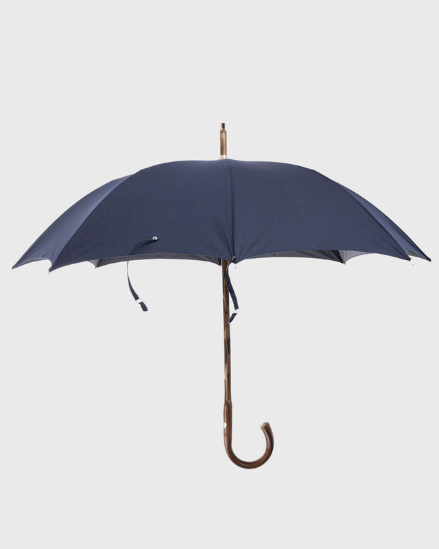 A navy blue umbrella with a curved wooden handle, shown open against a light gray background.